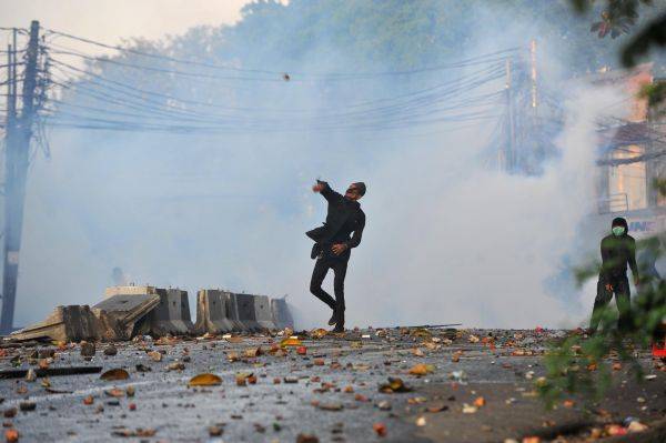 ▲5月22日，在印度尼西亚首都雅加达，一名示威者投掷石块。（新华社）
