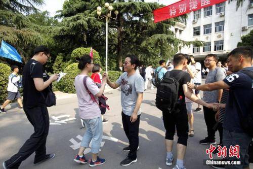 资料图：2018年6月7日，山东省实验中学考点，考生们陆续走进考场，老师为考生们加油鼓劲。中新社记者王占波摄