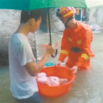 洪水围困 消防员用盆转移婴儿