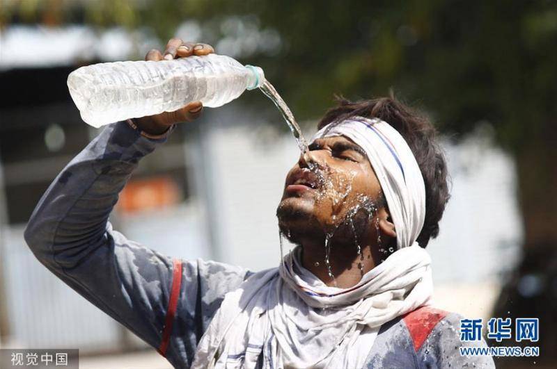 印度多地迎来高温天气 人们街头浇水降温