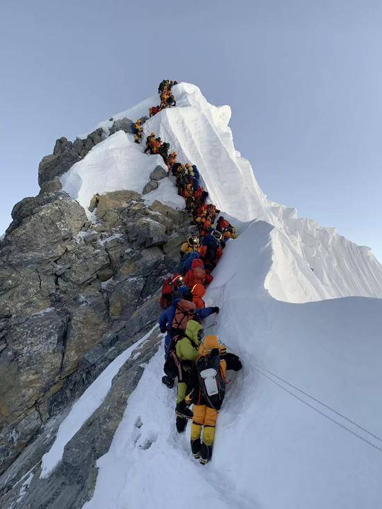 ▲登山者抓着登山绳排队等待。受访者供图