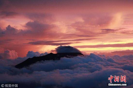 资料图片：印度尼西亚日惹，默拉皮火山在阳光的映衬下蔚为壮观。图片来源：视觉中国