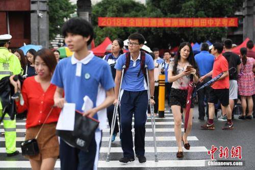 资料图：2018年6月7日，2018年高考进入第一天。图为福田中学考场外，一位高考生带伤上考场。中新社记者陈文摄