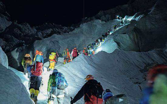 5月22日，昆布冰川中搭了十几部梯子以帮助登山者通过沟壑高坡，攀登者在前面排起长队准备依次通过。摄影/Rocker