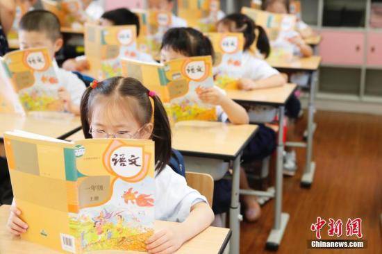 资料图：孩子们正在认真阅读《语文》教材。殷立勤摄