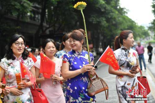  6月7日，成都树德中学考点外，一些学生家长穿上旗袍手持向日葵为孩子加油助阵，寓意“旗开得胜”和“一举夺魁”。张浪摄