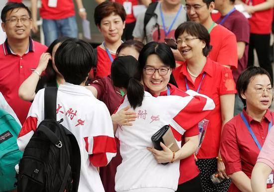 ▲2019年6月7日，北京，中国人民大学附属中学外，老师拥抱将参加高考的学生。