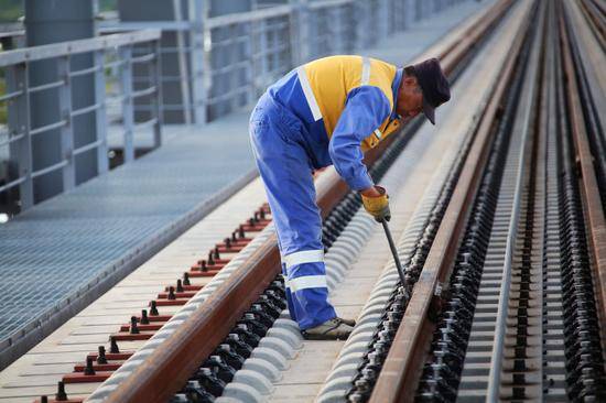 ▲中铁大桥局中俄同江铁路大桥项目的建设者正在对钢轨精度进行微调。（6月4日摄）本报记者谢锐佳摄