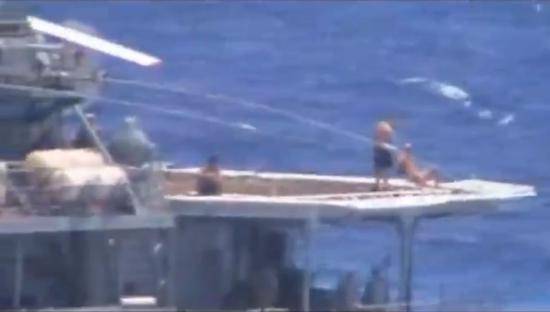 视频截图中展示的俄军海员正在直升机甲板上享受日光浴