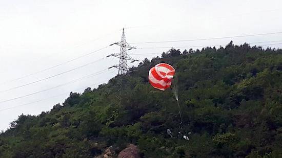 飞行员跳伞逃生，降落伞被挂在树上（韩联社）