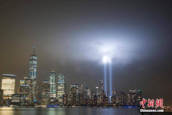 资料图：当地时间2018年9月11日，美国“911事件”17周年，纽约世贸中心附近两根象征着世贸中心双子塔的蓝色光柱直冲云霄，一直持续到黎明。中新社记者廖攀摄
