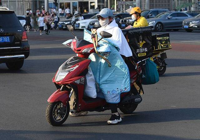 北京高温蓝色预警市民花样防晒组图