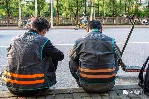 2018年6月24日，上海，两名滴滴代驾坐在路边刷单，查看手机滴滴叫车信息。视觉中国供图