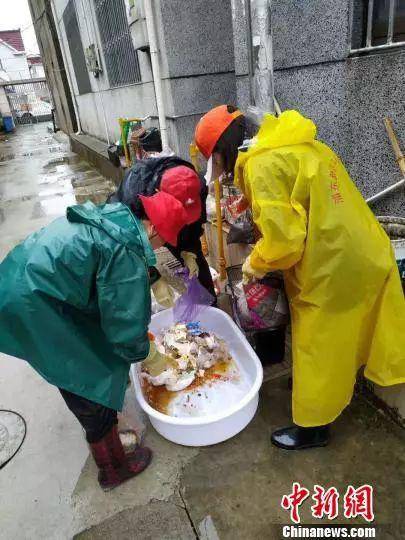 资料图：《上海市生活垃圾管理条例》实施首日，志愿者雨中仔细区分干湿垃圾。芊烨摄