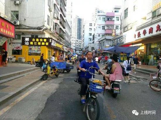 道路尽头是高档小区，和白石洲有着鲜明的对比。摄影：梁宙