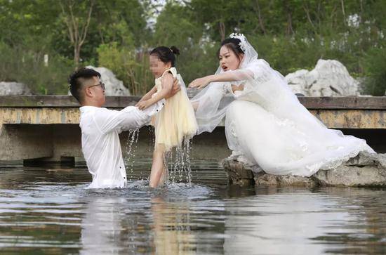 新人在拍婚纱照时遇一女童落水 新郎直接跳水救人