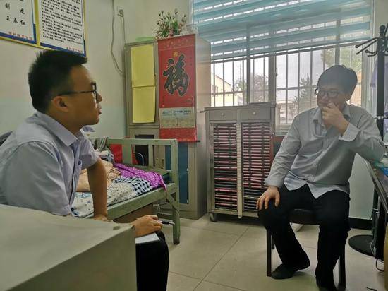 ▲在朱砂镇卫生院内，农民日报、中国农网记者正在采访朱砂镇一村医。
