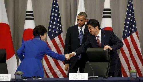 2016年3月31日，时任韩国总统朴槿惠（左）和日本首相安倍晋三（右）在时任美国总统奥巴马（中）的注视下握手。新华社/路透