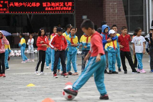 北京的职业足球教练给“追风”少年带来了足球装备与技术