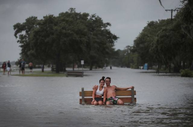 飓风带来暴雨，一对男女坐在公园长椅上（来源：Getty）