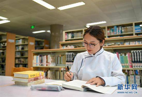 7月16日，内蒙古大学学生包高娃在图书馆学习。新华社记者彭源摄