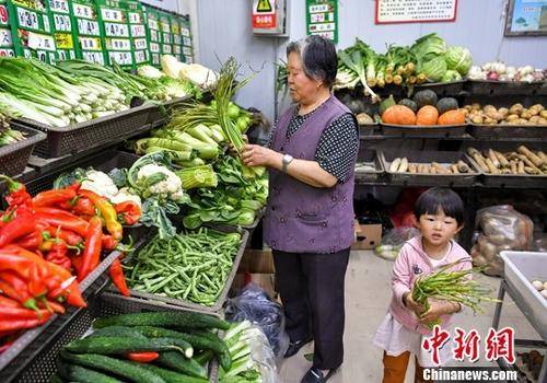 资料图：市民在居住地附近的社区蔬菜副食品直销点，购买新鲜蔬菜等食材。中新社记者刘新摄