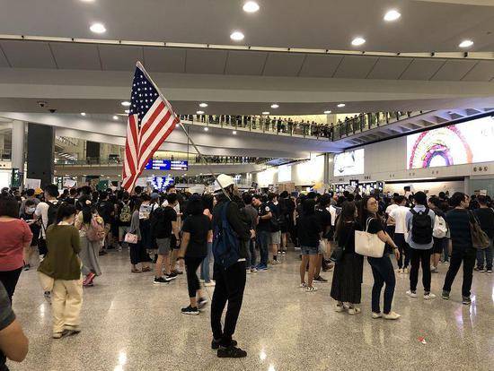 反对派滋扰香港机场误导旅客 还有人打出美国旗