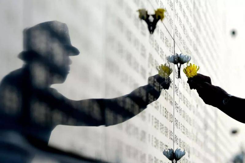 一位男士在唐山大地震罹难者纪念墙悼念遇难者。新华社记者吴晓凌摄