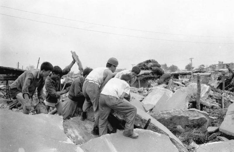 这是1976年7月28日大地震发生后，人们在清理废墟。新华社记者官天一摄