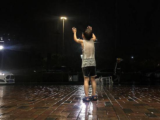 分钟寺，男孩在雨中玩耍，衣服全部湿透。