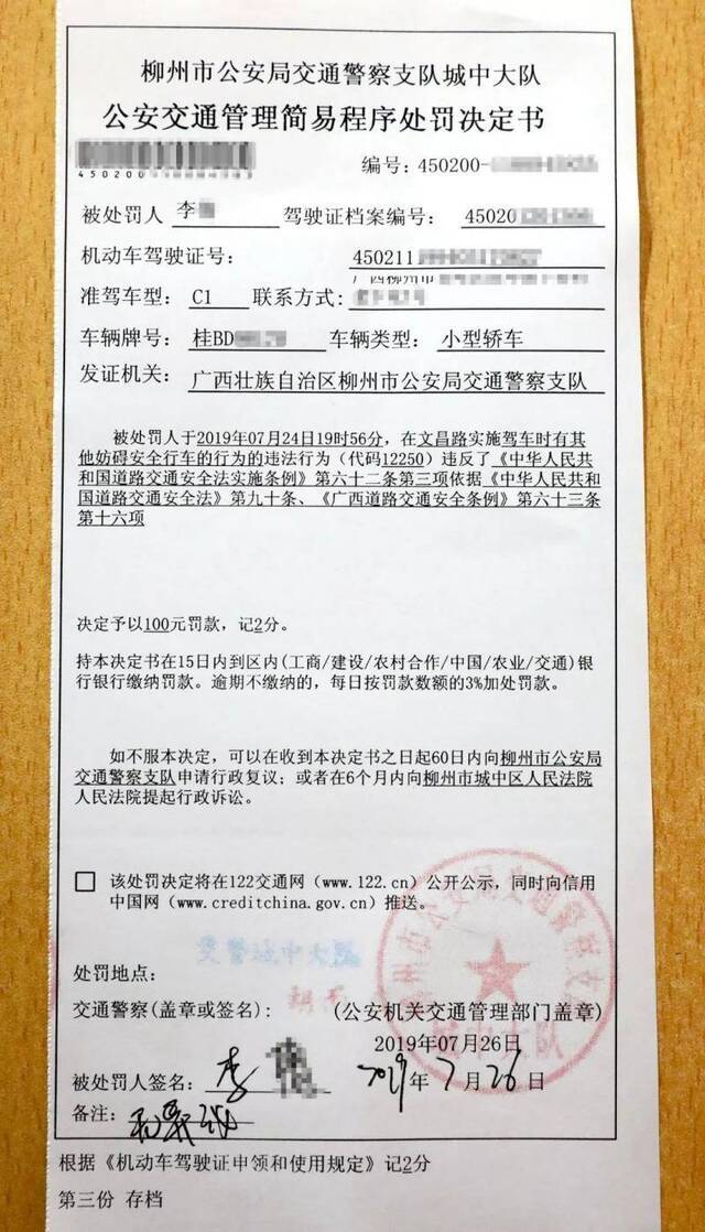 女司机驾车马路中间龟速遛狗 交警罚款100元记2分