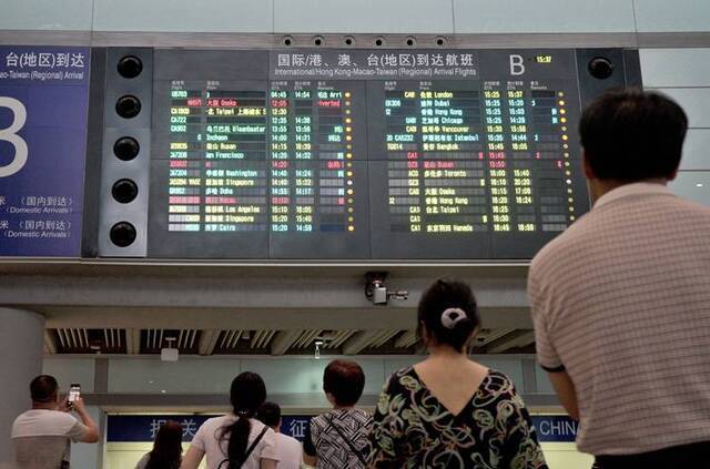 首都机场T3航站楼，大屏幕显示国家游泳队所乘坐的航班属于备降状态。