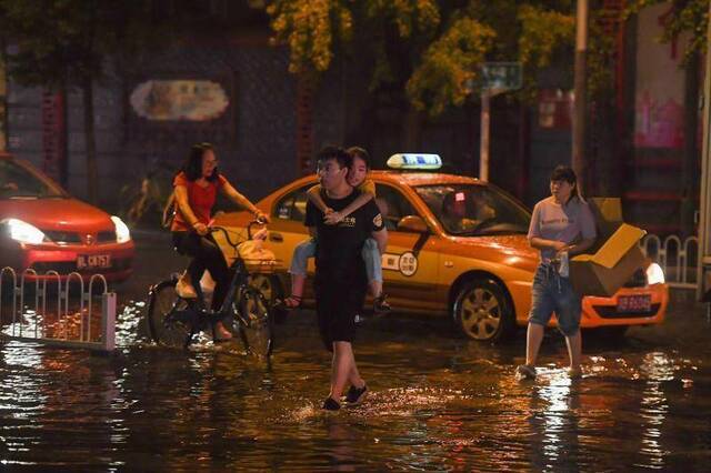 北京大雨金台路积水 抢险人员撬井盖排水