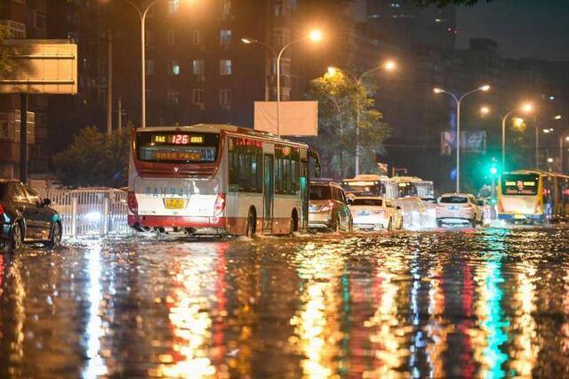 北京大雨金台路积水 抢险人员撬井盖排水