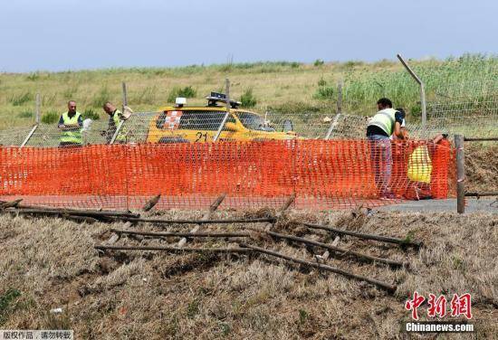 当地时间7月28日，意大利罗马西南40公里处菲乌米奇诺附近的Focene，遭遇龙卷风袭击，现场一片狼藉。图为工作人员在修复当地加油站一处受损的栅栏。