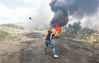 5月10日，在约旦河西岸城市纳布卢斯附近，巴勒斯坦示威者向以色列士兵投掷石块。新华社发