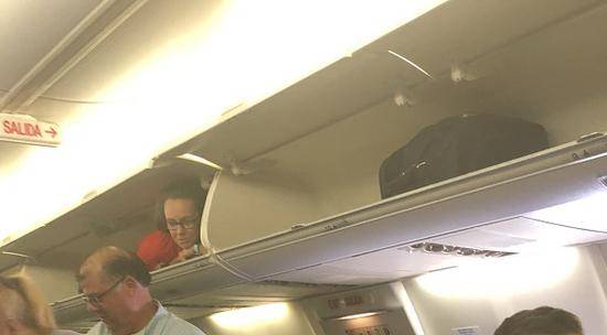 空姐趴在行李架上。（图源：推特）