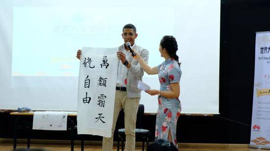 ▲资料图片：4月21日，在摩洛哥卡萨布兰卡，来自穆罕默德五世大学孔子学院的穆罕默德·阿明·泽拉德（中文名安天翔）在比赛中展示书法。（新华社）