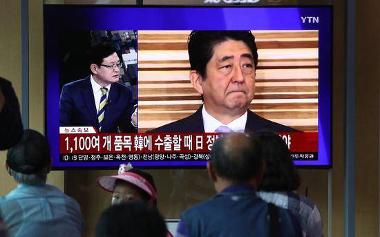首尔市民们观看关于日本政府把韩国剔除出“白名单”的报道。图/视觉中国