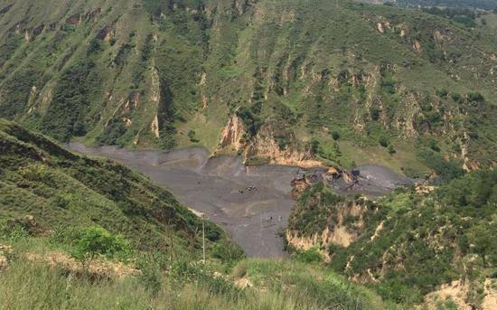 ▲山洪过后，洗煤厂上游河道淤积的大量煤泥。新京报记者张胜坡摄