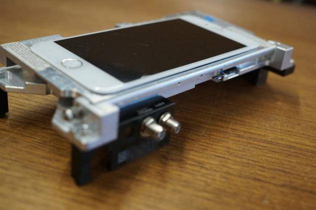 一台安装在支架上的“dev-fused”版iPhone（Image: Motherboard）