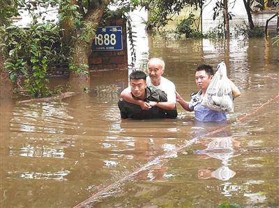 8月2日，四川乐山突降暴雨，河水漫过堤岸，民房被淹。当地民警和消防人员将被困老人背出。乐山市公安局供图