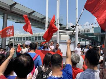 30名香港市民尖沙咀举国旗唱国歌 谴责乱港示威者