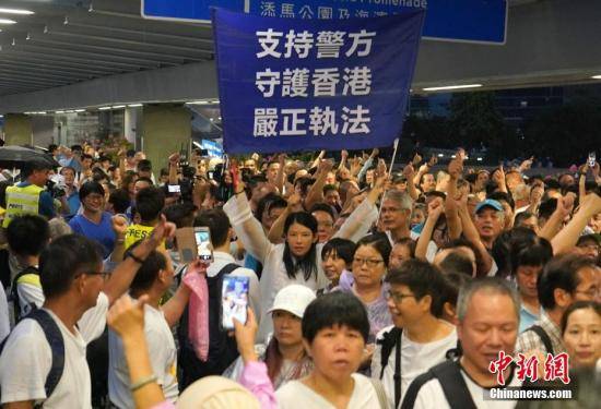7月20日下午，30余万香港市民在金钟添马公园参加“守护香港”集会，共同守护香港法治的核心价值，维护法治，反对暴力。图为集会结束后，一名市民高举支持警方的横幅，市民纷纷竖起大拇指，高喊“支持警察”的口号。中新社记者张炜摄