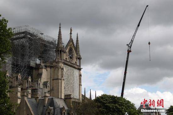 当地时间2019年4月27日，维护人员为在大火中严重损毁的巴黎圣母院顶部加装防雨设施，并为圣母院外部一些比较脆弱的结构加装防护网等设施。中新社记者李洋摄