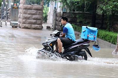 受“利奇马”影响山东潍坊普降大雨市民在道路积水中前行