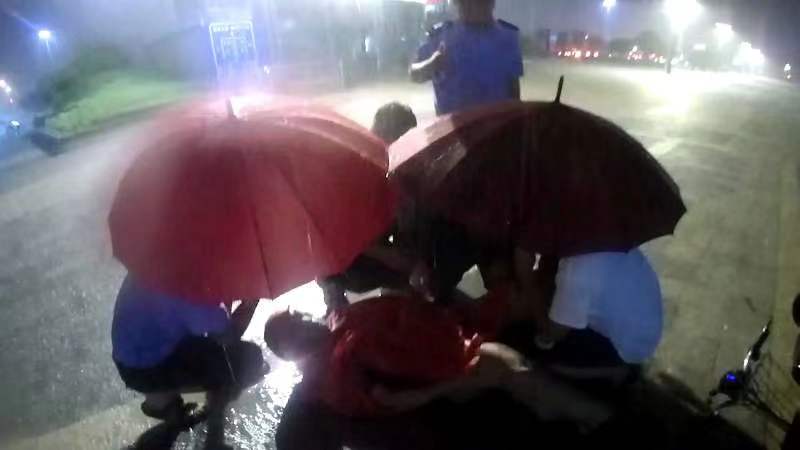 雨夜中的那抹藏蓝 半跪撑伞守护受伤群众​