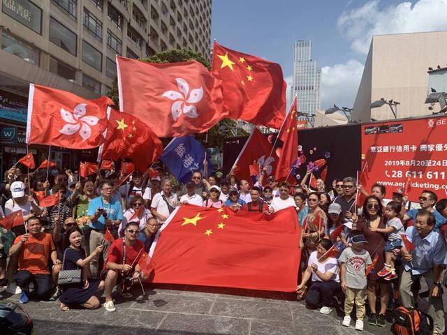 尖沙咀五支旗杆旁高举中国国旗和香港特别行政区区旗（图源：大公报）