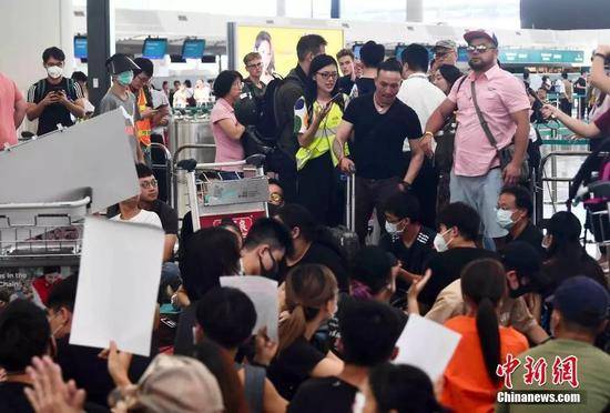 8月13日下午，大批示威者以机场手推车等堵塞香港国际机场1号客运大楼旅客登机行段及保安闸门，旅客未能经1号客运大楼前往离境大堂。中新社记者麦尚旻摄