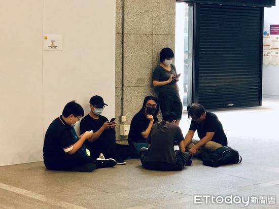 “黑衣人”坐在地上（图源：台湾“东森新闻云”）